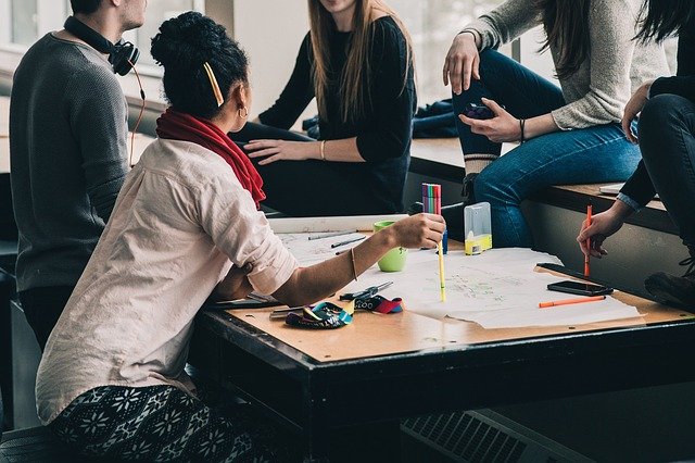 personne assise derrière son bureau qui communique avec autres personnes